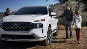 A family of three standing near a white 2022 Hyundai Santa Fe. | Hyundai dealer in Fort Smith, AR.