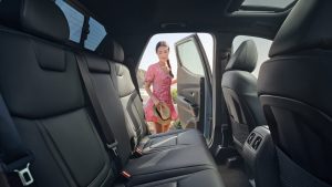 Interior view of the backseat of a 2022 Hyundai Santa Cruz with a woman holding the door open. | Hyundai dealer in Fort Smith, AR.