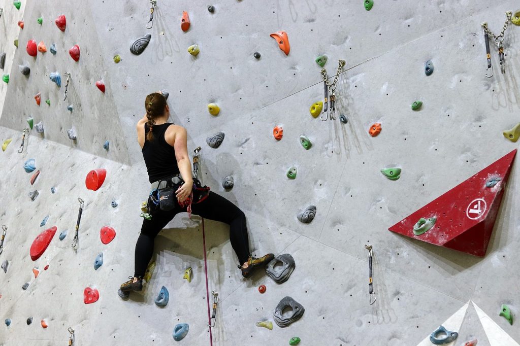 A woman climbing on an indoor rock climbing wall. | Fun activities to do in Fort Smith, AR | Crain Hyundai of Fort Smith