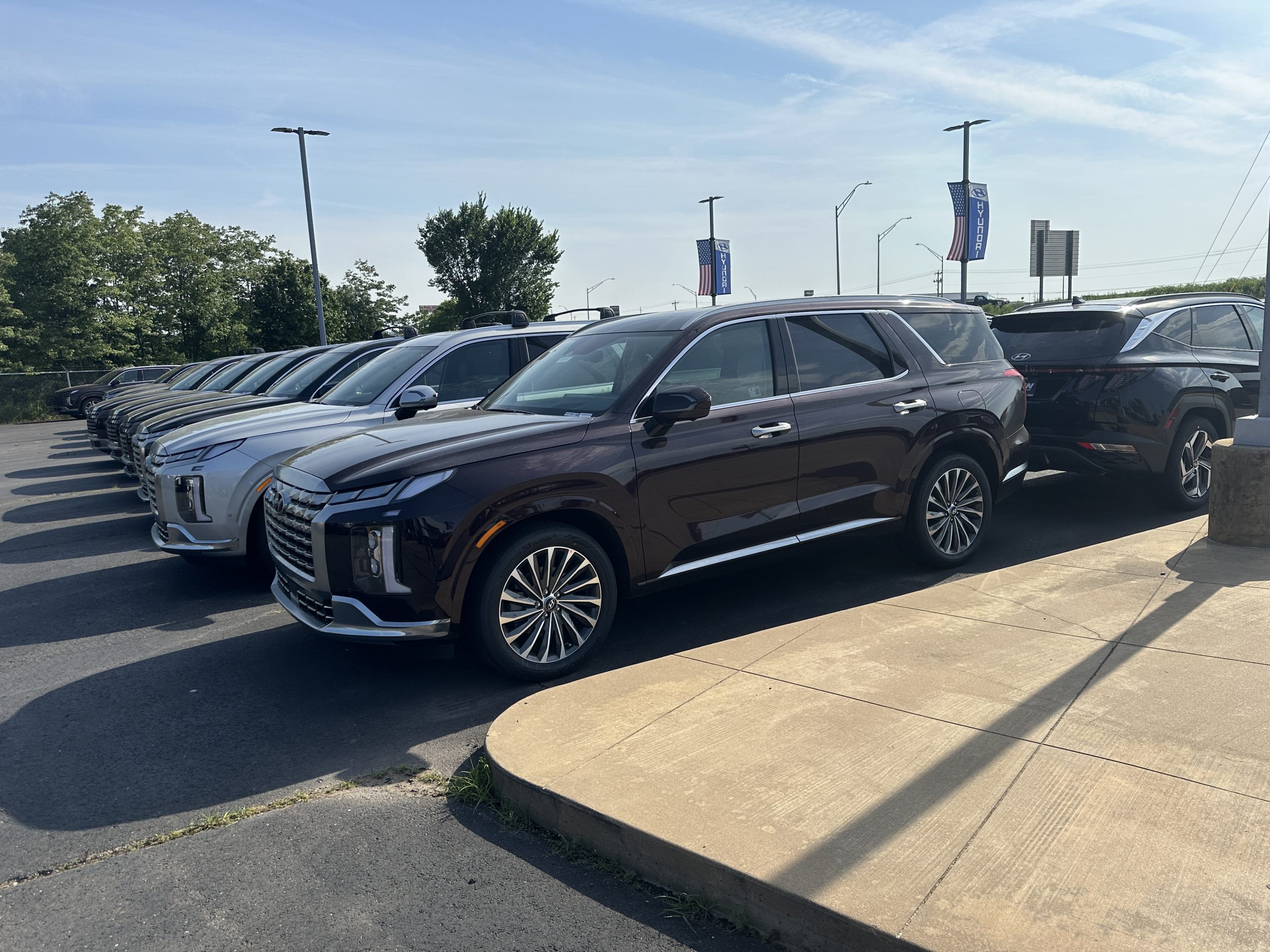 Lineup of Hyundai SUVs at a dealership lot on a sunny day
